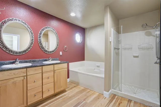 a bathroom with a double vanity sink mirror and bathtub