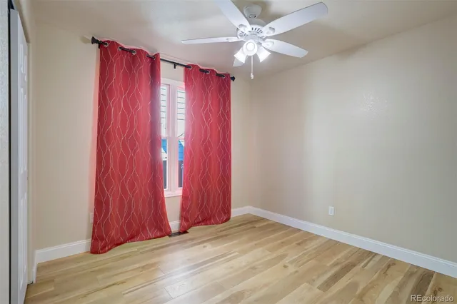 a view of a bedroom with wooden floor and windows