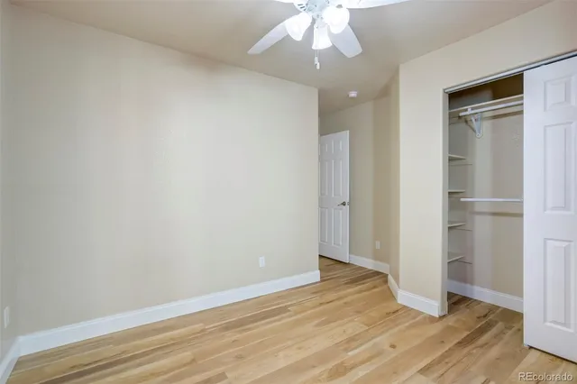an empty room with wooden floor and hallway