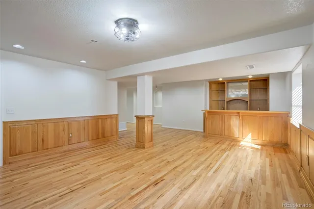 a view of empty room with wooden floor