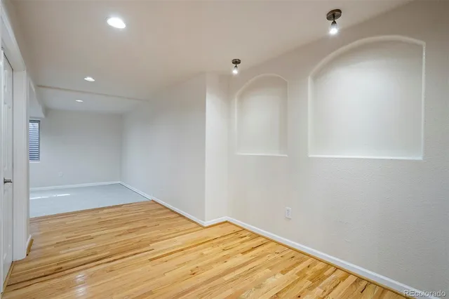 a view of empty room with wooden floor