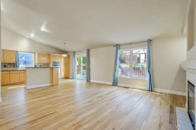 a view of a kitchen with wooden floor and a window