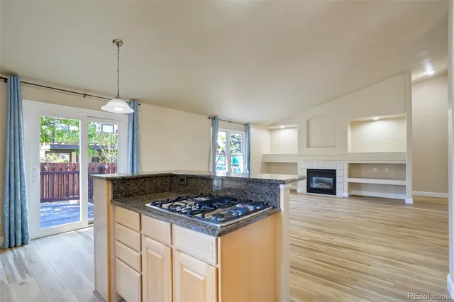 a kitchen with granite countertop a stove and a wooden floor