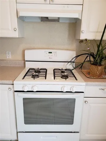 a stove top oven sitting inside of a kitchen