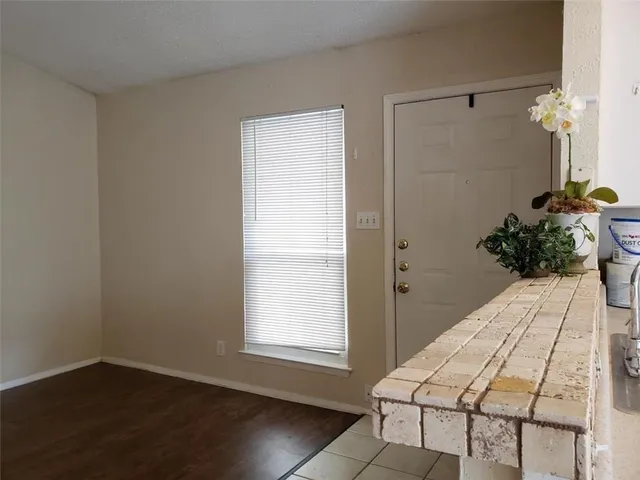 a view of a bedroom with wooden floor and a potted plant