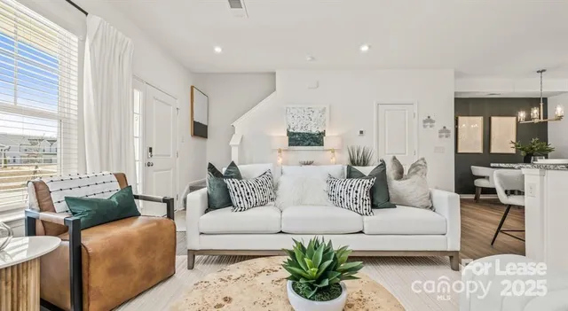 a living room with furniture potted plant and white walls