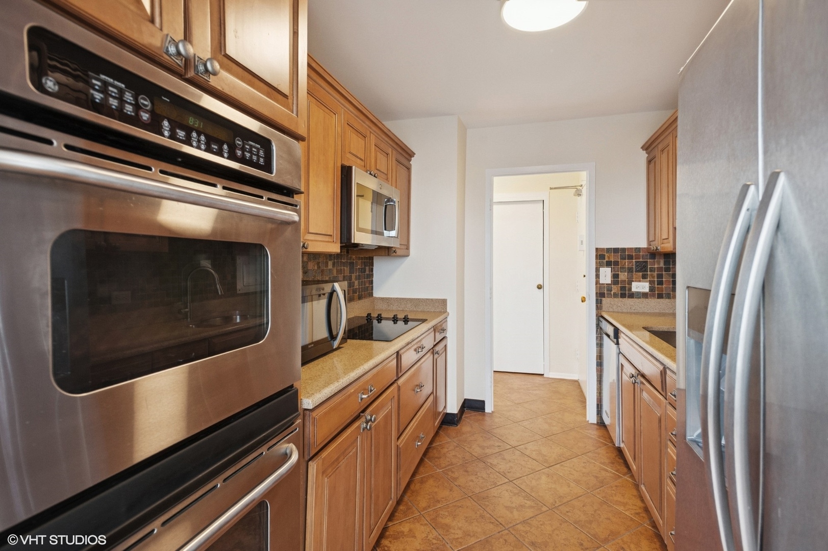 5757 North Sheridan Road, Unit 20J Chicago, IL 60660 - Photo 6 of 20 a kitchen with stainless steel appliances a stove microwave and cabinets