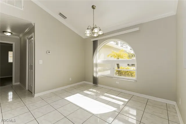 an empty room with windows and chandelier