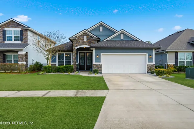 a front view of a house with a yard and trees