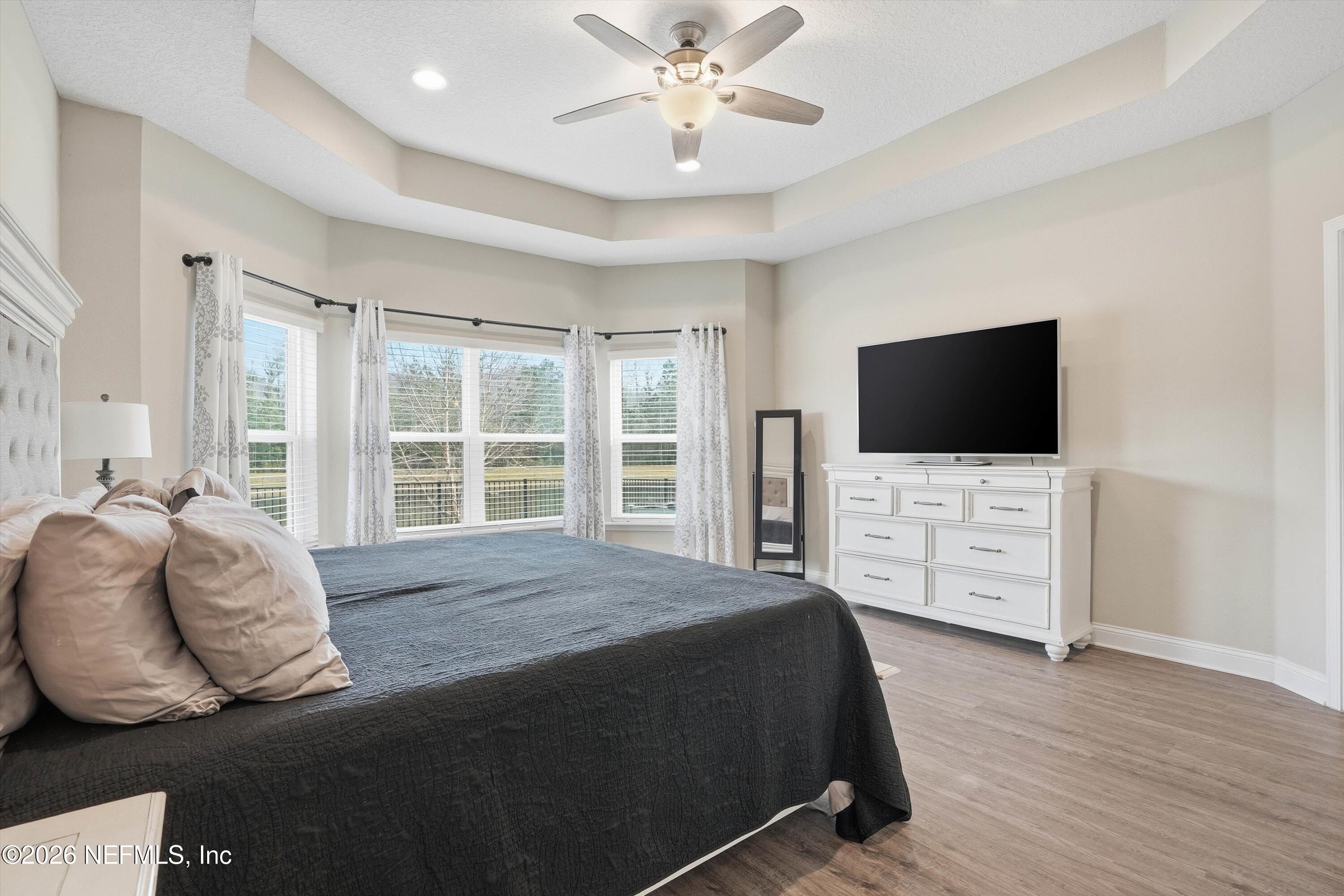 742 Sycamore Way Orange Park, FL 32073 - Photo 14 of 41 a spacious bedroom with a bed and a flat screen tv