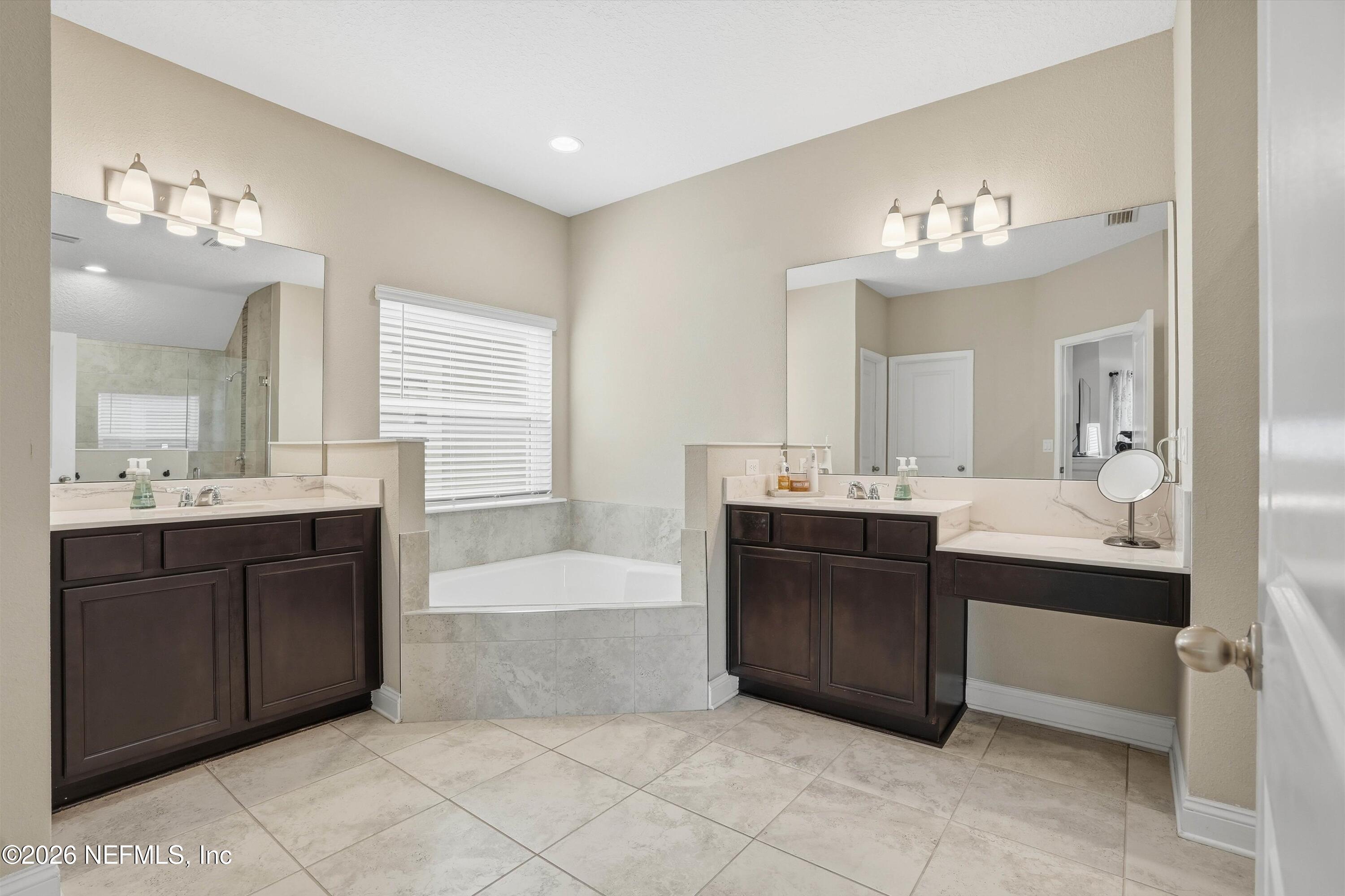 742 Sycamore Way Orange Park, FL 32073 - Photo 15 of 41 a bathroom with a sink vanity tub and a mirror