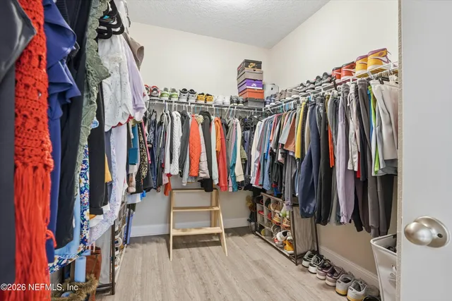 a view of walk in closet with clothes