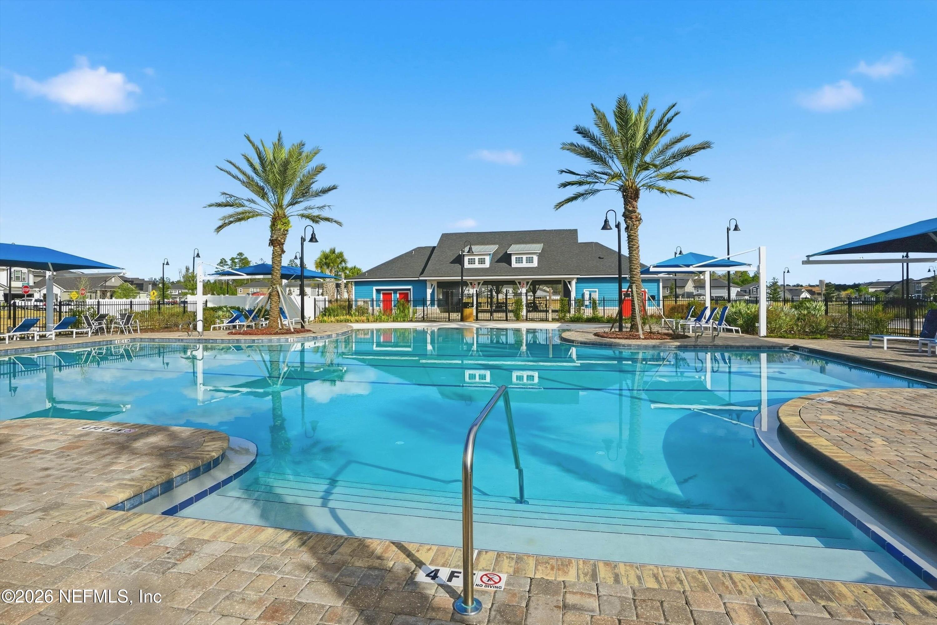 742 Sycamore Way Orange Park, FL 32073 - Photo 39 of 41 a view of a swimming pool with a lawn chairs under an umbrella
