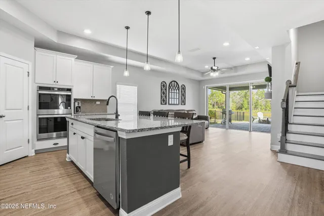 a large kitchen with stainless steel appliances kitchen island granite countertop a large center island attached withe living room