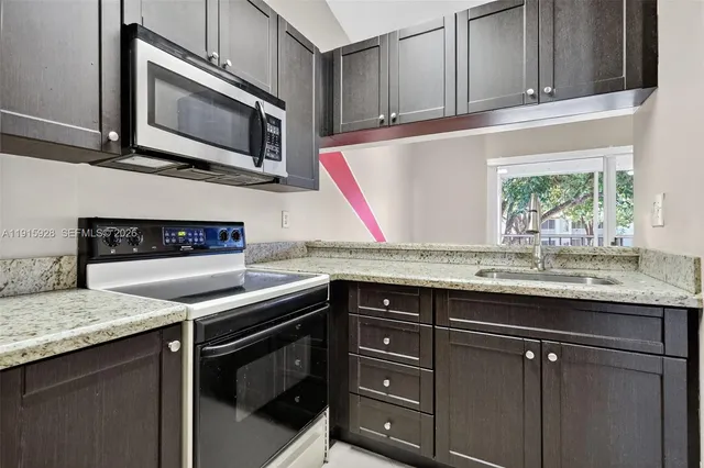a kitchen with granite countertop a sink and cabinets