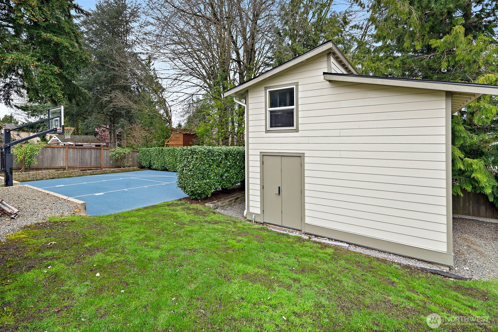 2219 236th Street Southeast Bothell, WA 98021 - Photo 28 of 34 a view of a white house in front of a yard with plants and large trees