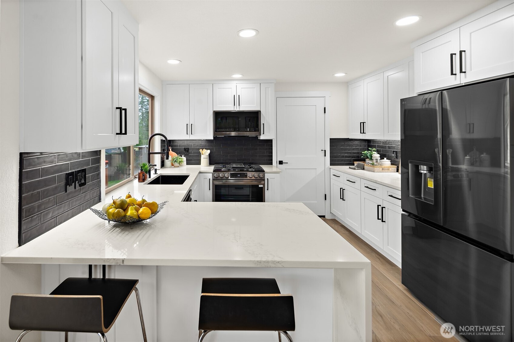2219 236th Street Southeast Bothell, WA 98021 - Photo 9 of 34 a kitchen with stainless steel appliances a refrigerator a sink a stove a oven a dining table and chairs