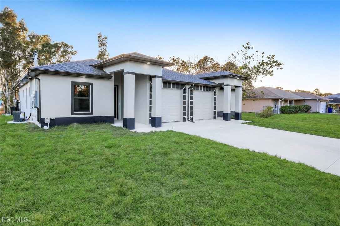4805-4807 29th Street Southwest Lehigh Acres, FL 33973 - Photo 2 of 25 a front view of a house with a garden and plants