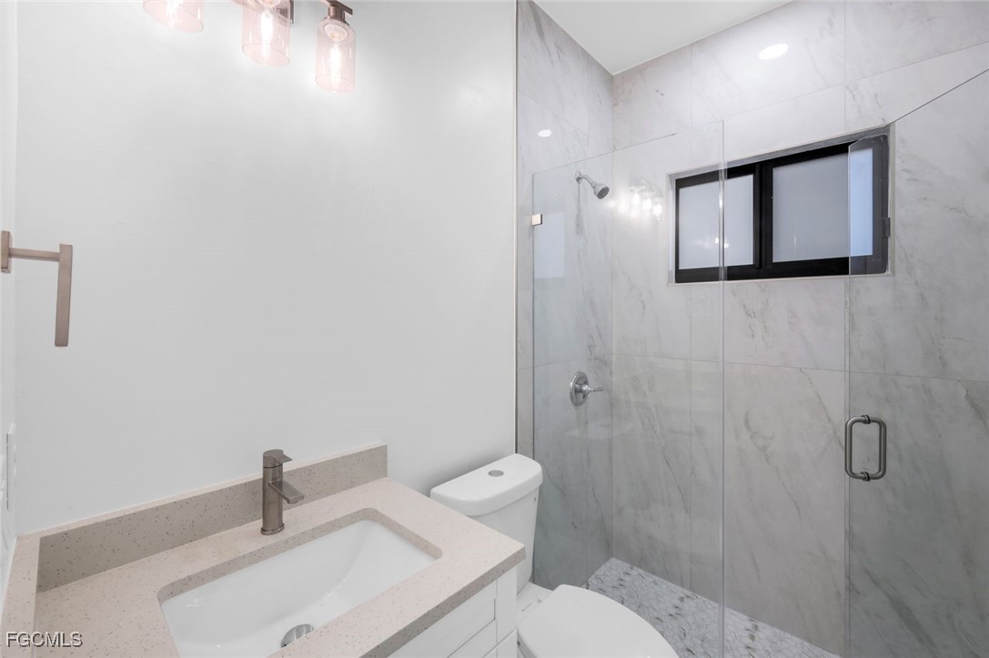 4805-4807 29th Street Southwest Lehigh Acres, FL 33973 - Photo 21 of 25 a bathroom with a toilet a sink and mirror