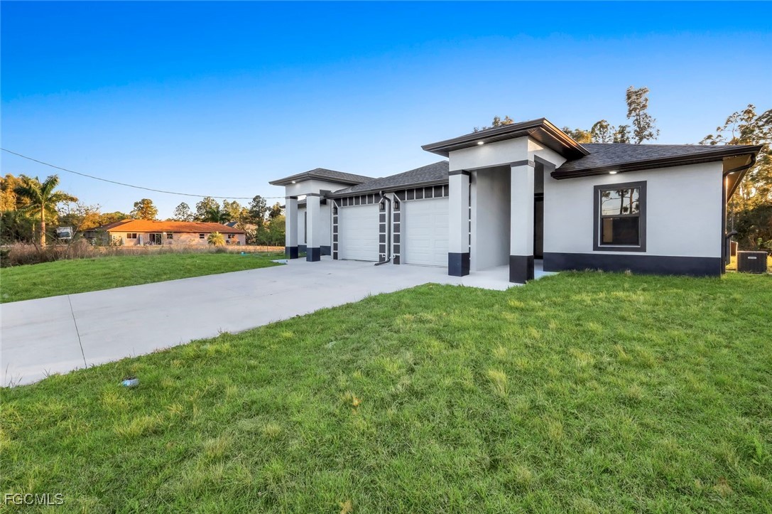 4805-4807 29th Street Southwest Lehigh Acres, FL 33973 - Photo 25 of 25 a front view of a house with a yard and garage