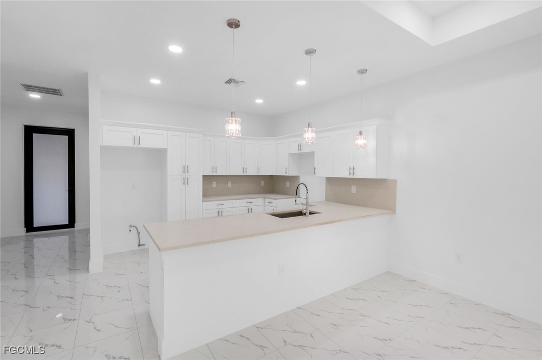 4805-4807 29th Street Southwest Lehigh Acres, FL 33973 - Photo 5 of 25 a large white kitchen with a sink and a refrigerator