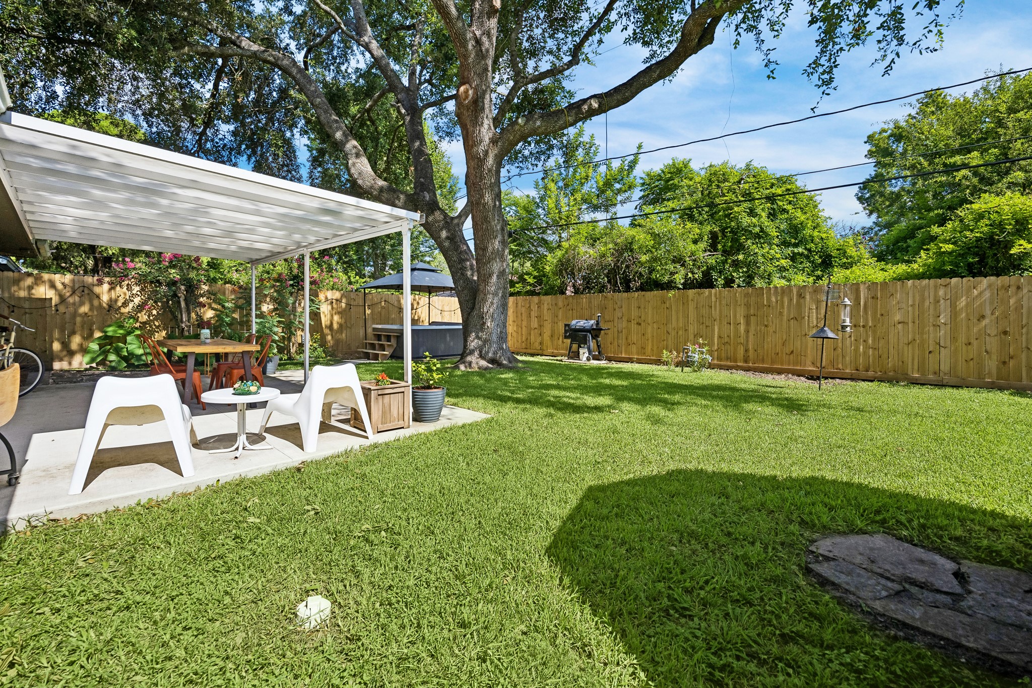 4514 Warm Springs Road Houston, TX 77035 - Photo 30 of 31 This backyard features a well-maintained lawn with a little bird bath to the right of the feeder, drawing in a variety of birds for watching.