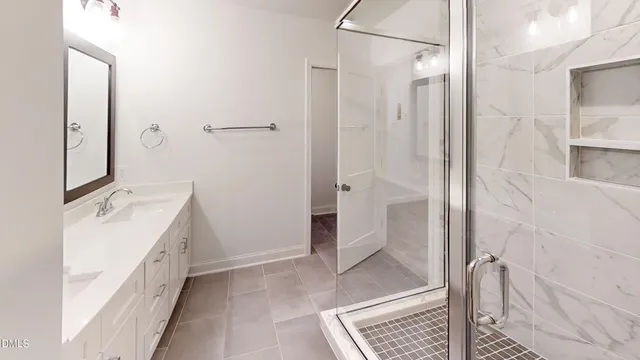 a bathroom with a double vanity sink a toilet and shower