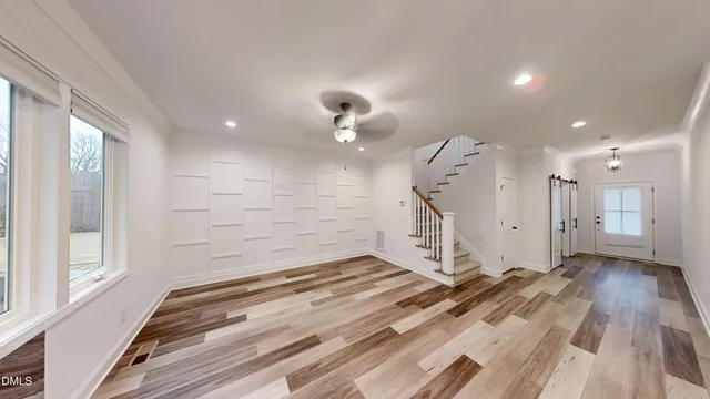 a view of empty room with wooden floor and windows