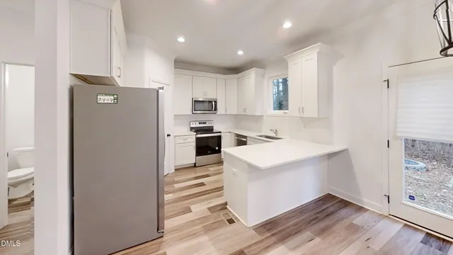 a kitchen with white cabinets and white appliances