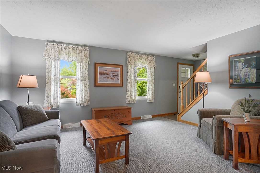 4190 Springdale Road Stow, OH 44224 - Photo 5 of 38 Carpeted living room featuring healthy amount of natural light, stairway, and baseboards