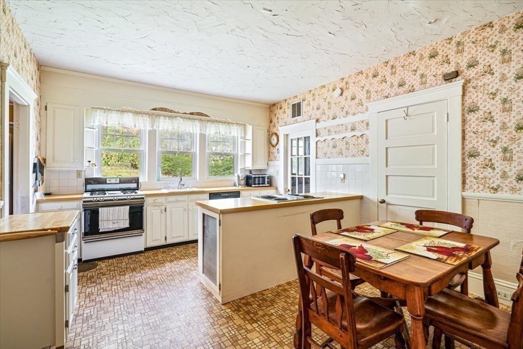 48 Neal Gate Street Scituate, MA 02066 - Photo 13 of 34 a kitchen with a table chairs stove and kitchen island