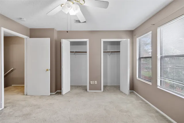 an empty room with windows and closet