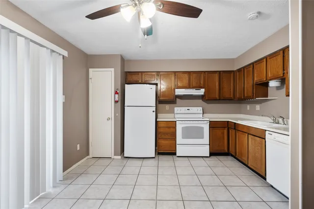 a kitchen with a refrigerator a stove top oven a sink and dishwasher