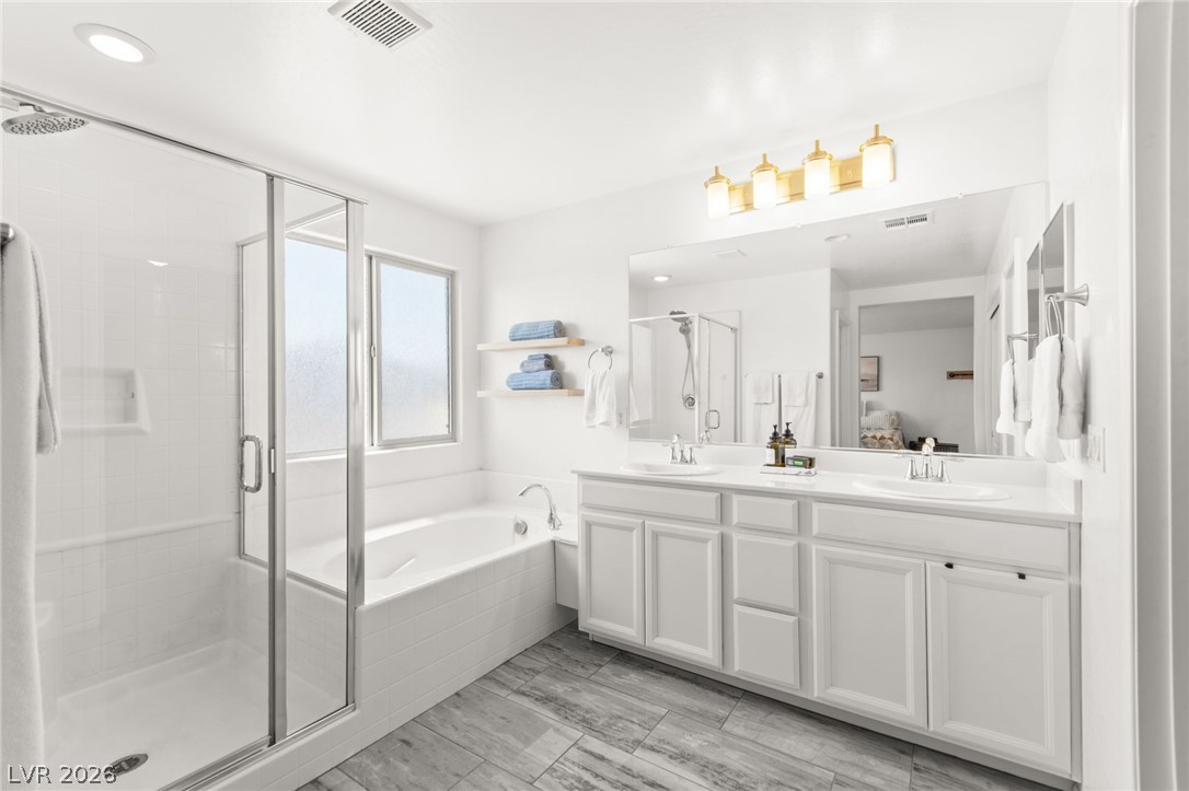 6435 Point Isabel Way Las Vegas, NV 89122 - Photo 28 of 57 Indulge in a tranquil primary bathroom offering a soaking tub, walk-in shower, and double vanity.