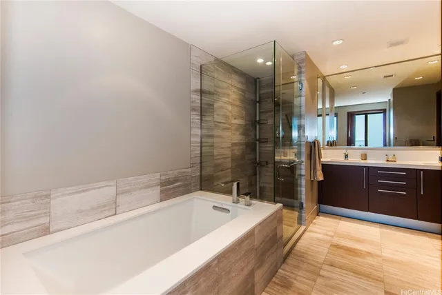 a spacious bathroom with a bathtub sink and mirror