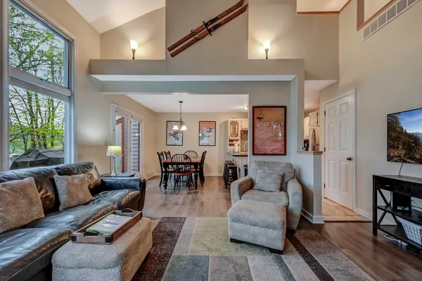 a kitchen with stainless steel appliances a stove a sink a microwave a dining table and chairs