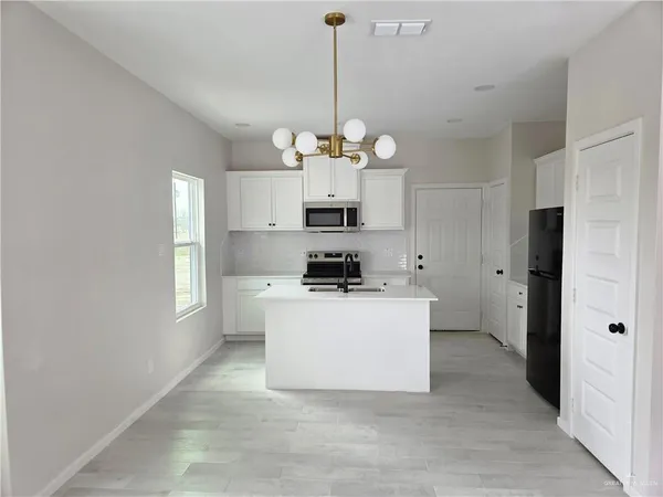 a view of a kitchen with a sink a refrigerator and window