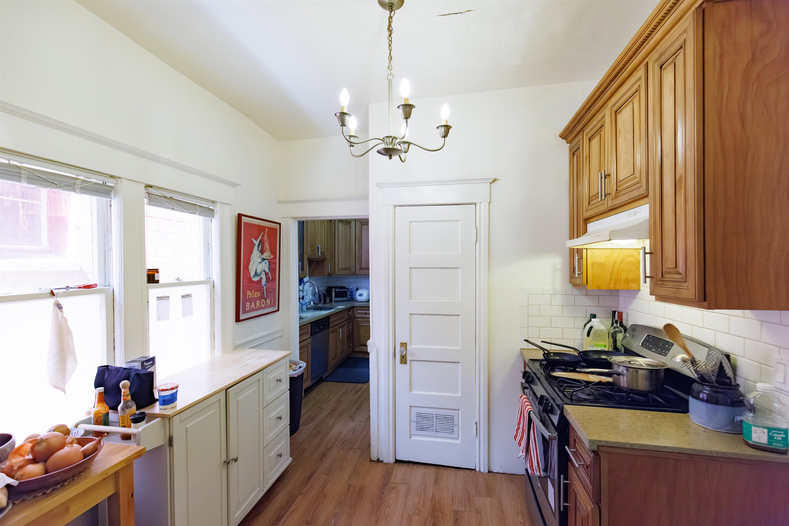 667 10th Street Oakland, CA 94607 - Photo 12 of 18 Kitchen featuring stainless steel gas range oven, light wood-style floors, a chandelier, backsplash, and wood finish cabinets