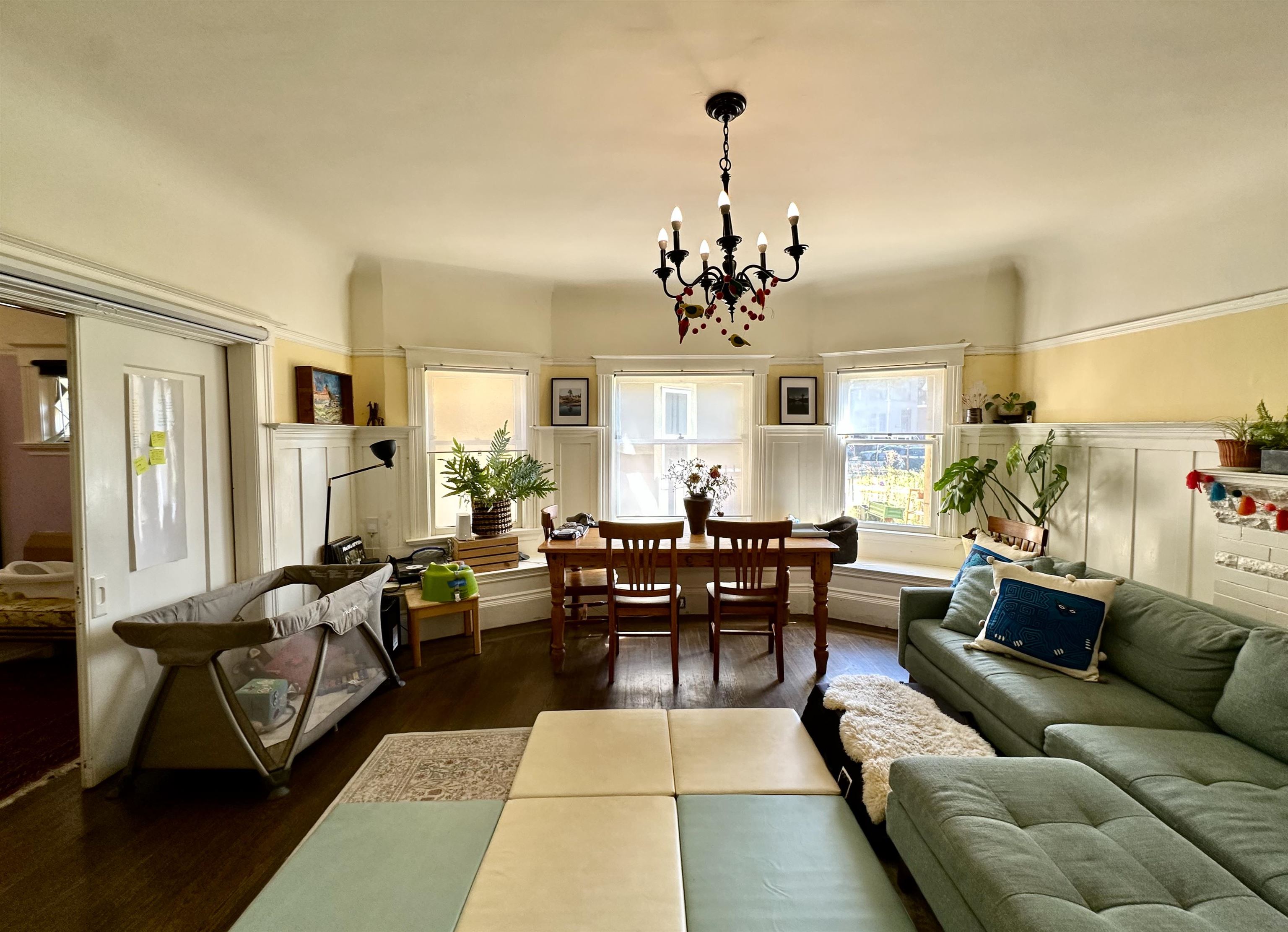 667 10th Street Oakland, CA 94607 - Photo 8 of 18 Living room with wood finished floors, suspended lighting, wainscoting, and a decorative wall