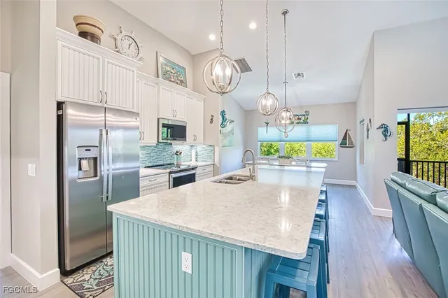a kitchen with granite countertop white cabinets and stainless steel appliances