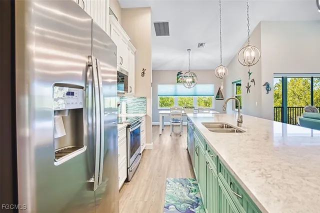 a kitchen with stainless steel appliances granite countertop a refrigerator a oven and a sink