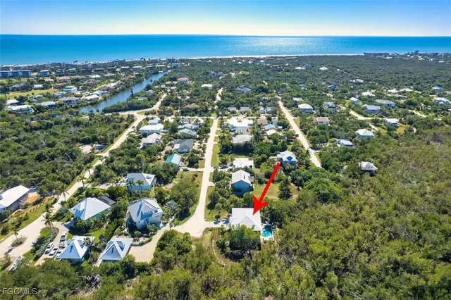 an aerial view of residential houses with outdoor space and trees