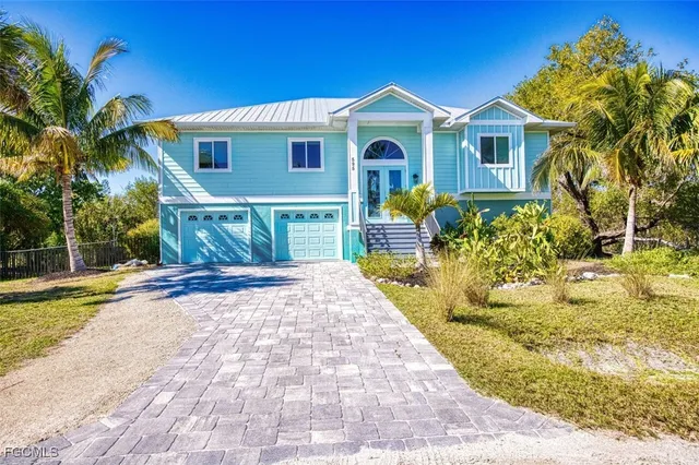 a front view of a house with a yard and potted plants