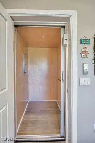 a view of a hallway with wooden floor and a cabinet