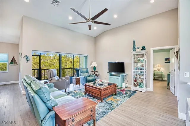 a living room with furniture a flat screen tv and a large window
