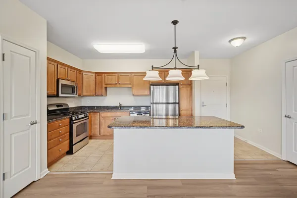 a kitchen with stainless steel appliances granite countertop a sink a stove and refrigerator