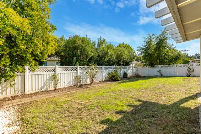 a front view of house with yard and trees in the background