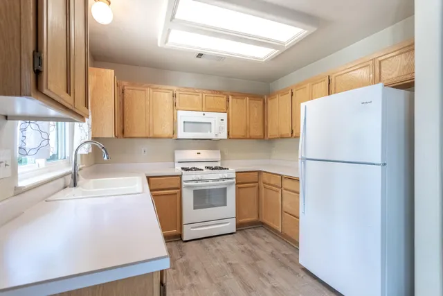 a kitchen with appliances a sink and a window