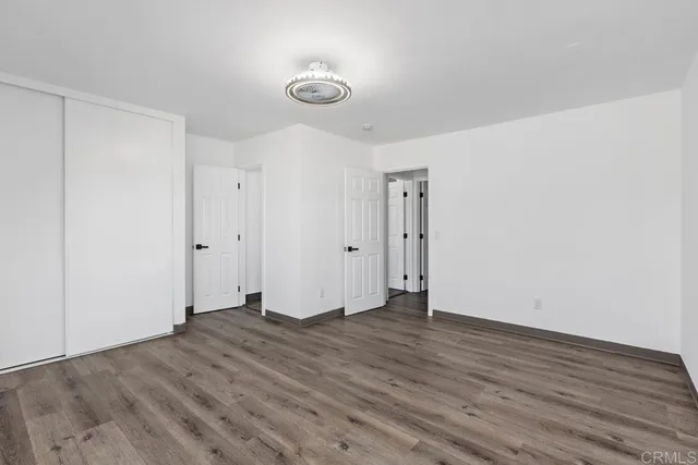 an empty room with wooden floor and window