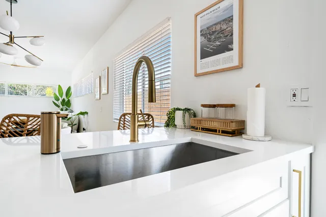 a kitchen with stainless steel appliances a sink a counter top space and living room